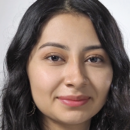 Headshot of a person with long dark hair and a neutral expression against a plain background.