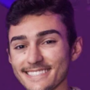 Headshot of a person smiling against a purple background.