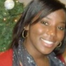 Headshot of a smiling person wearing a scarf and earrings, with a Christmas tree and ornament in the background.