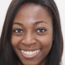 Headshot of a person with long dark hair, smiling, against a plain white background.