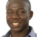 Headshot of a person smiling, wearing a striped shirt, with a plain white background.