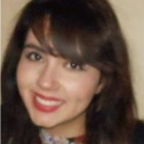 A headshot of a person with long dark hair and a warm smile, wearing a floral-patterned top.