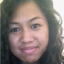 A headshot of a person with long, curly hair, smiling slightly, and looking at the camera.