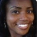 Headshot of a person smiling with long dark hair and wearing earrings.